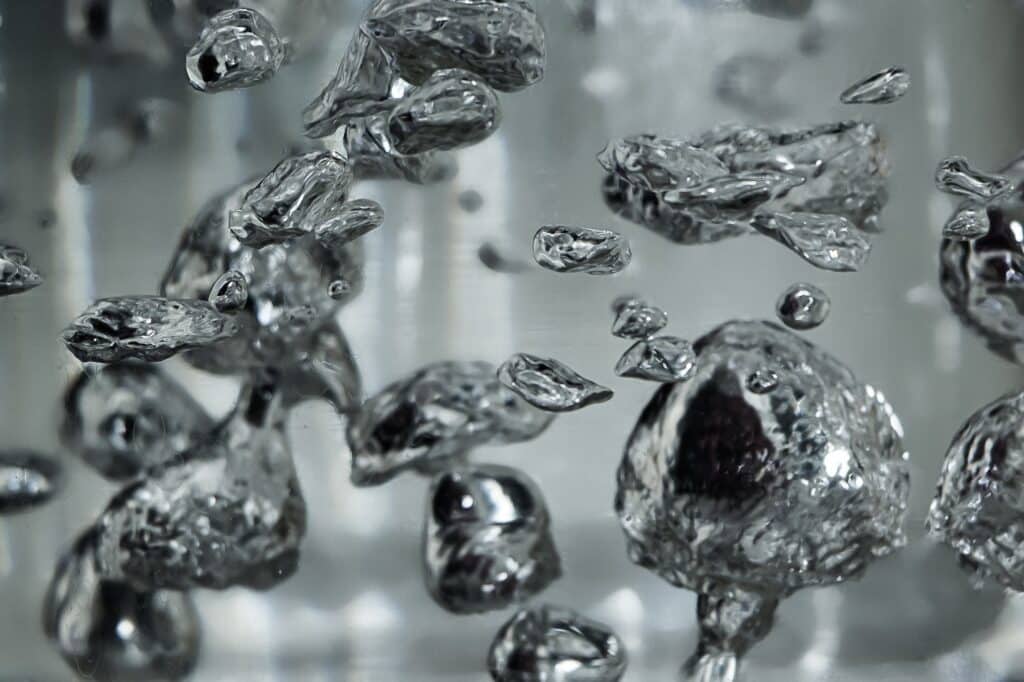 Drops and bubbles of mercury in water. Dangerous chemical element, the scientific experience.